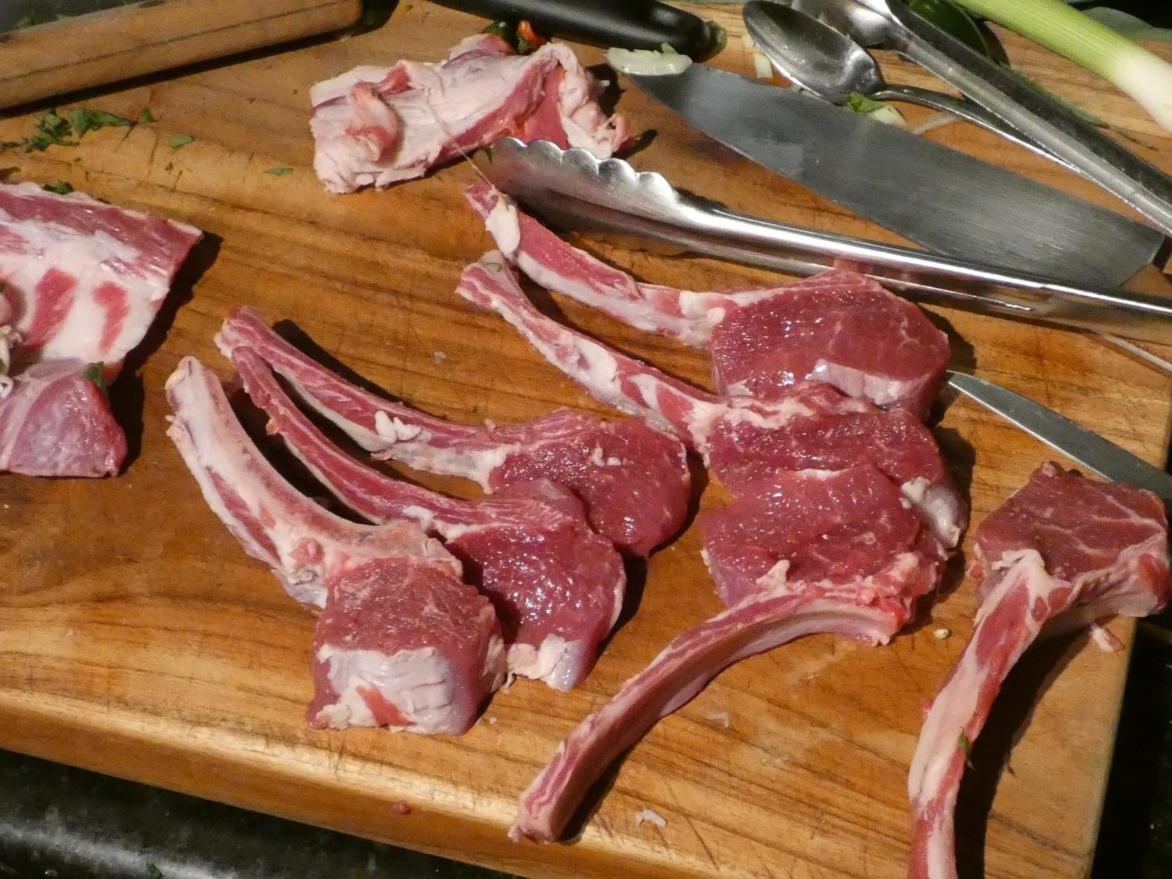 Dorper+Sheep Block of butter on parchment paper with sliced pieces, placed on a wooden cutting board, surrounded by a light-colored cloth and a knife. Ideal for cooking and baking.